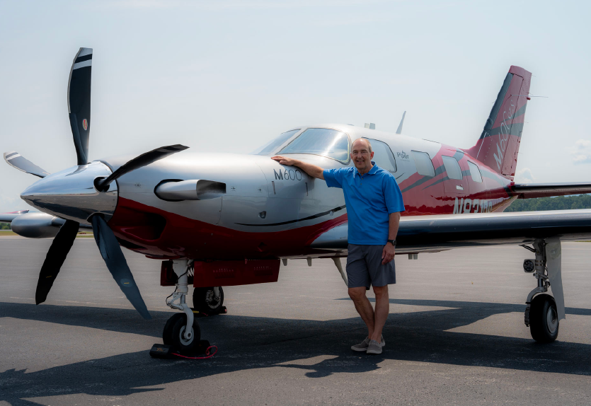Phil Soucy poses for a photo with his aircraft